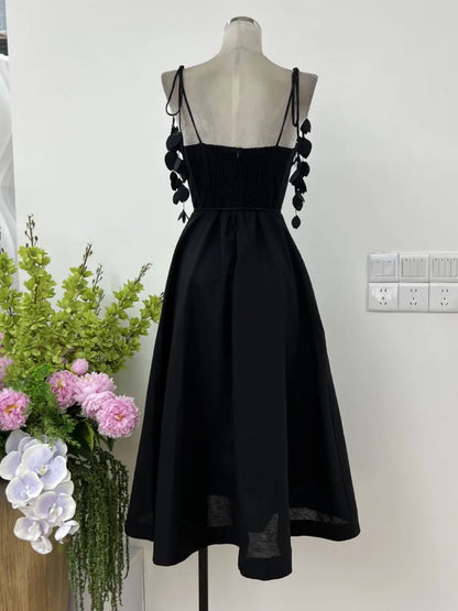 JNMC Black Floral Lace Vacation Dress – Beach-Ready Elegance for WomenJNMC Black Temperament Design Sense Spring And Summer New Flower Lace Shoulder Strap Vacation Beach Style Dress For Women 2024